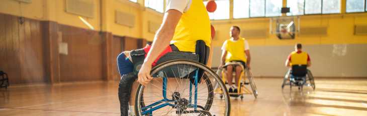 an image a person on a wheelchair while playing an adaptive basketball game